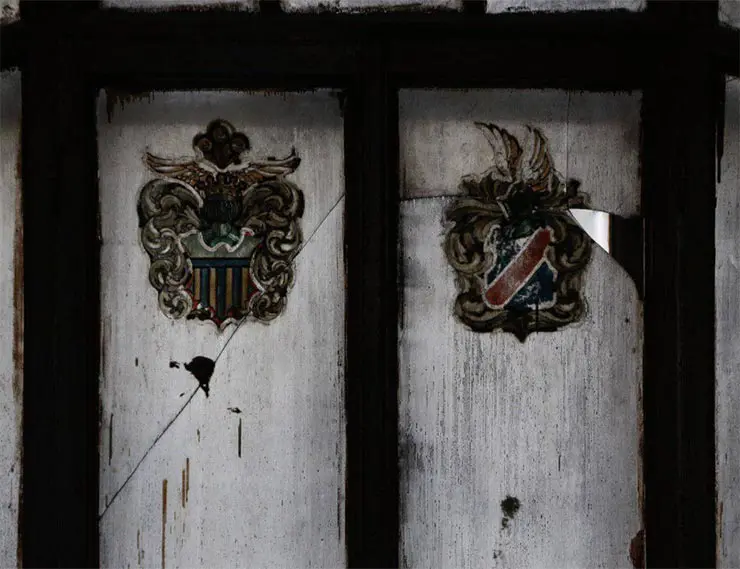 Створки окна украшены изображениями гербов